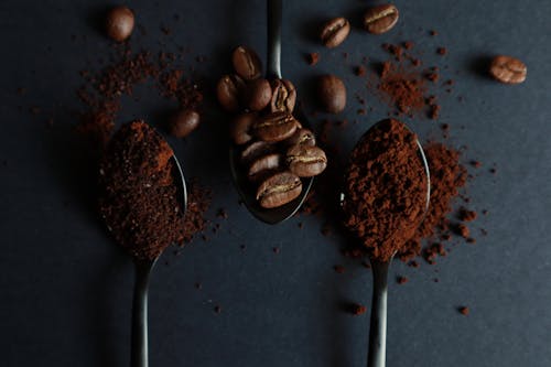 Photo of Spoons with Roasted Coffee Beans and Ground Coffee