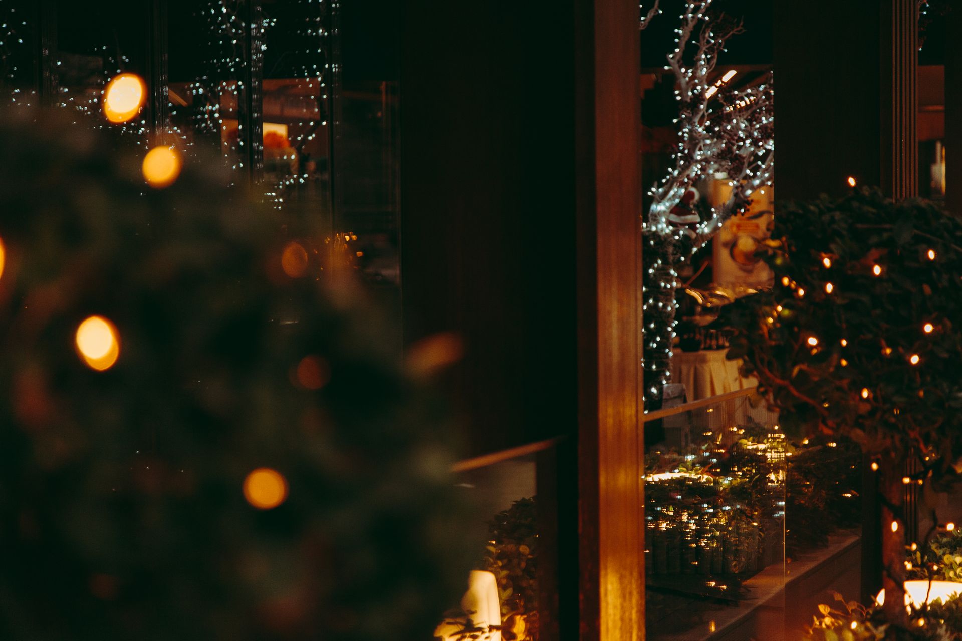Reflection of festive holiday lights on glass panels creates a cozy atmosphere.
