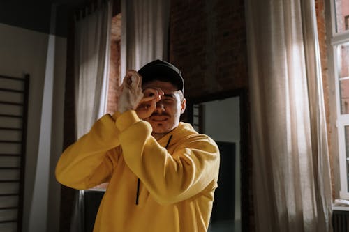 Man In Yellow Hoodie Sweater Doing Hand Signs