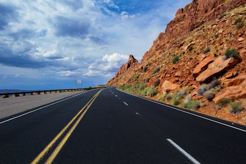 An Empty Road Near the Brown Rock Formations