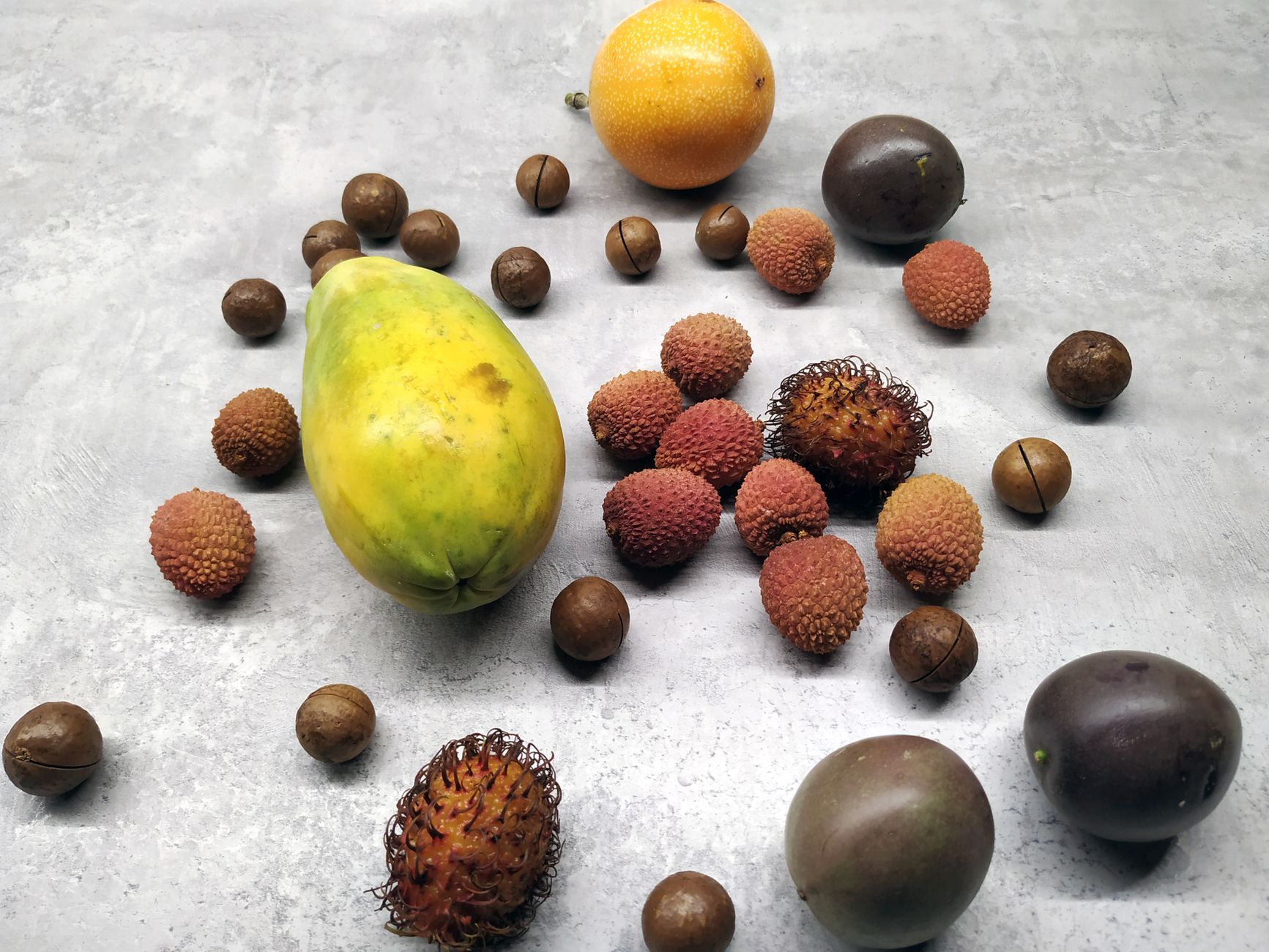 Close up of lychee and rambutan fruit side by side showing skin texture differences