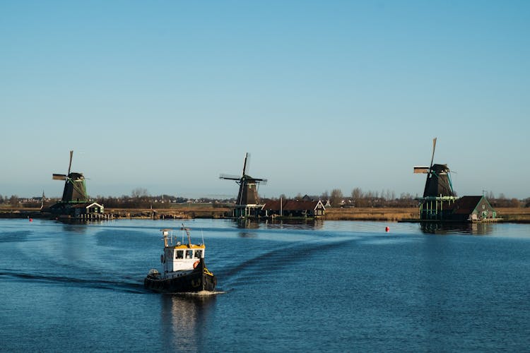 Windmills And Boat On Sea