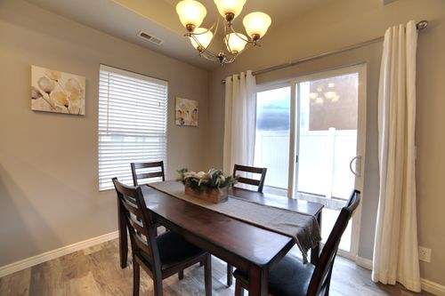 Free A cozy dining room featuring a wooden table, chairs, and an elegant chandelier. Stock Photo