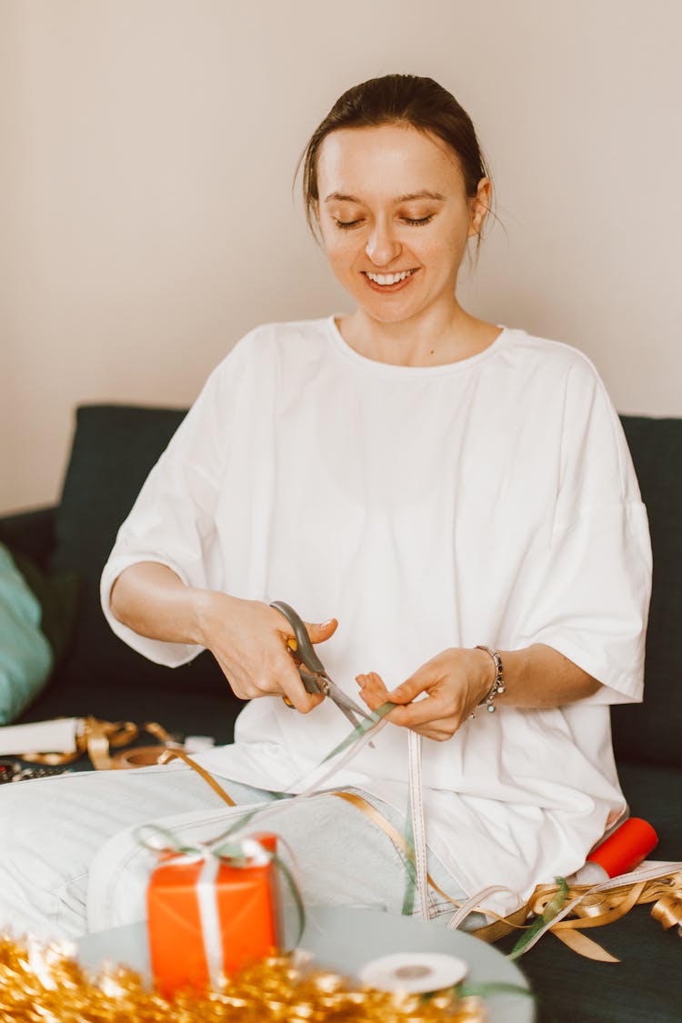 A Woman Cutting A Gift Ribbon