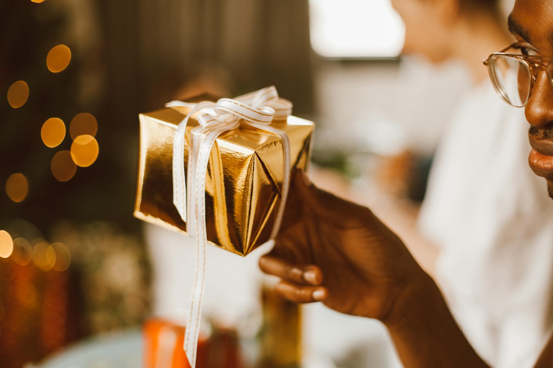 A Man Holding a Gift Box with Ribbon