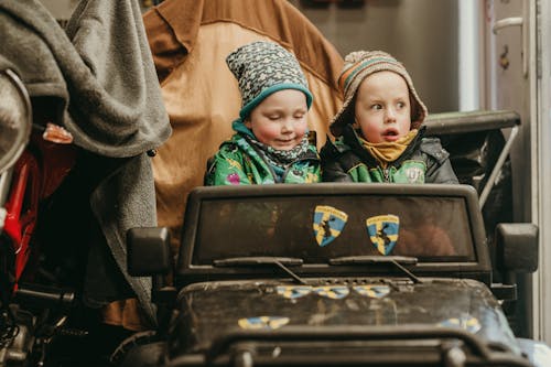 Young Kids Sitting on a Toy Car