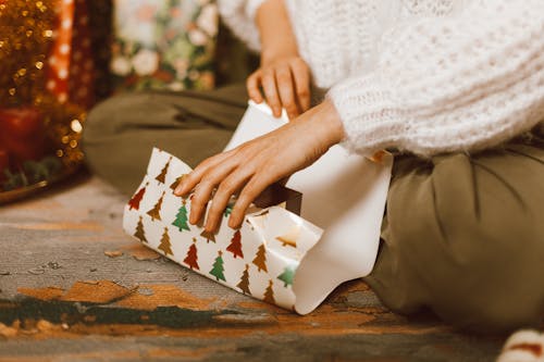 Free Woman Sitting on the Floor and Wrapping a Present Stock Photo