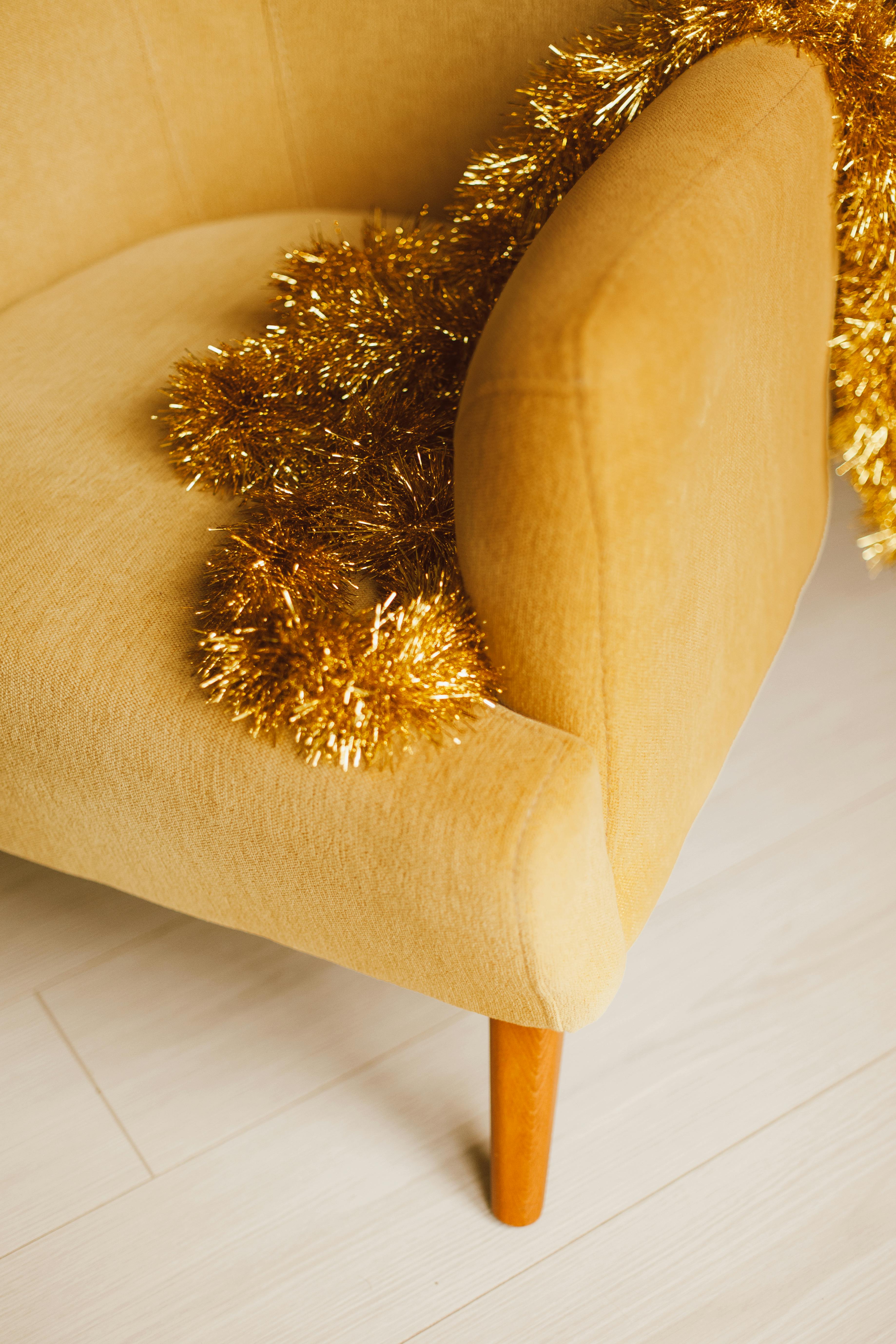 golden christmas tree decoration lying on yellow chair