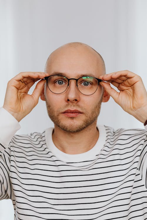 Man Holding Temples of Eyeglasses