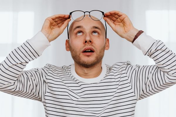 Person adjusting their eyeglasses