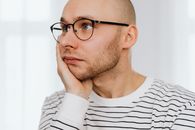 Unhappy Man with Hand on Cheek