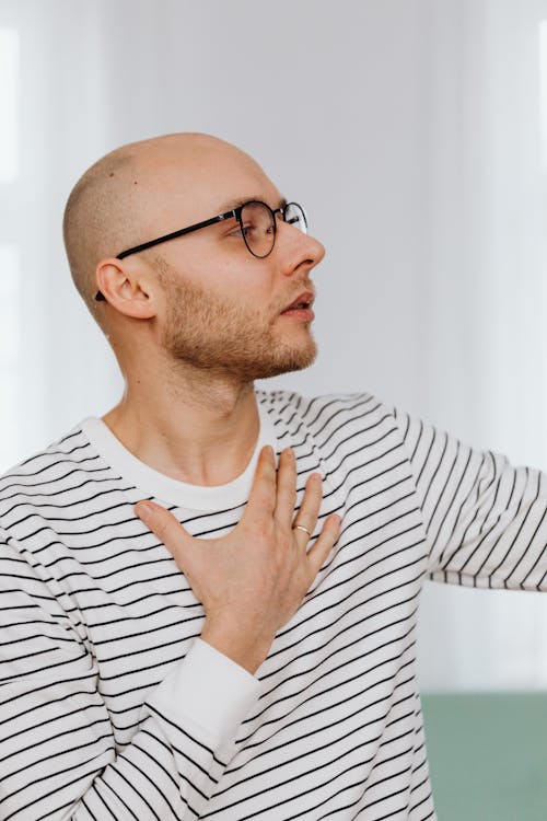 Man Wearing Eyeglasses Posing with Hand on Chest