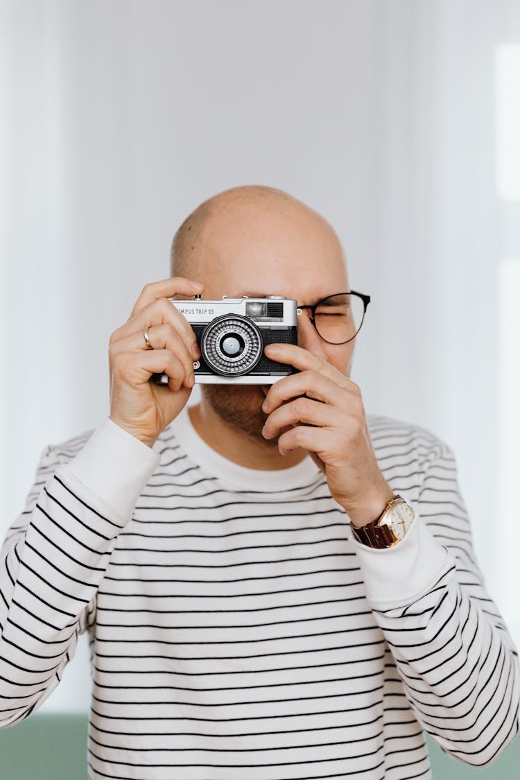 Bald Man In Glasses Taking A Photo With A Camera