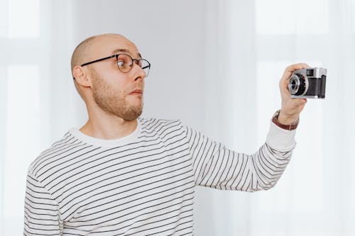 Free Man Making a Funny Face and Taking a Selfie with a Camera  Stock Photo