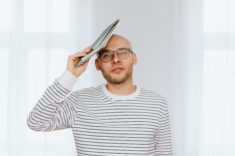 Man Holding A Folder On His Head