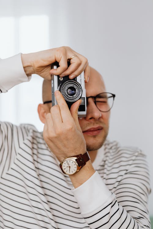 Man in Striped Shirt Taking Pictures