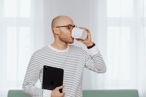Man in Stripe Long Sleeve Shirt Drinking from a Mug