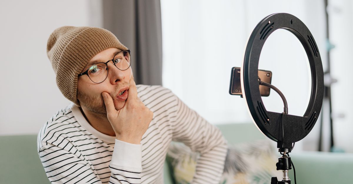 TikTok creator filming content on smartphone ring light setup