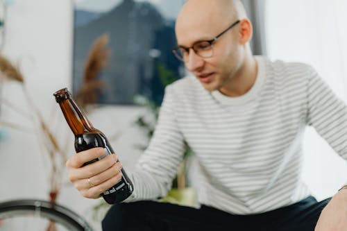 A Man Looking at the Beer Bottle