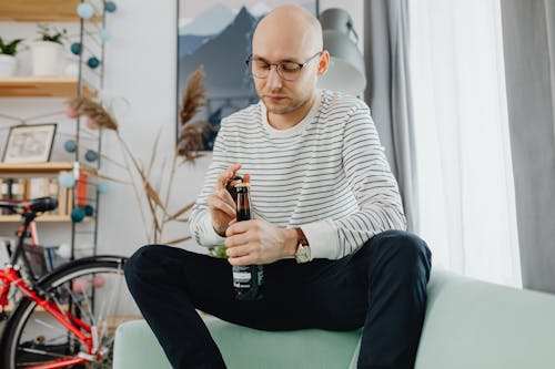 Free A Man Opening a Beer Bottle Stock Photo