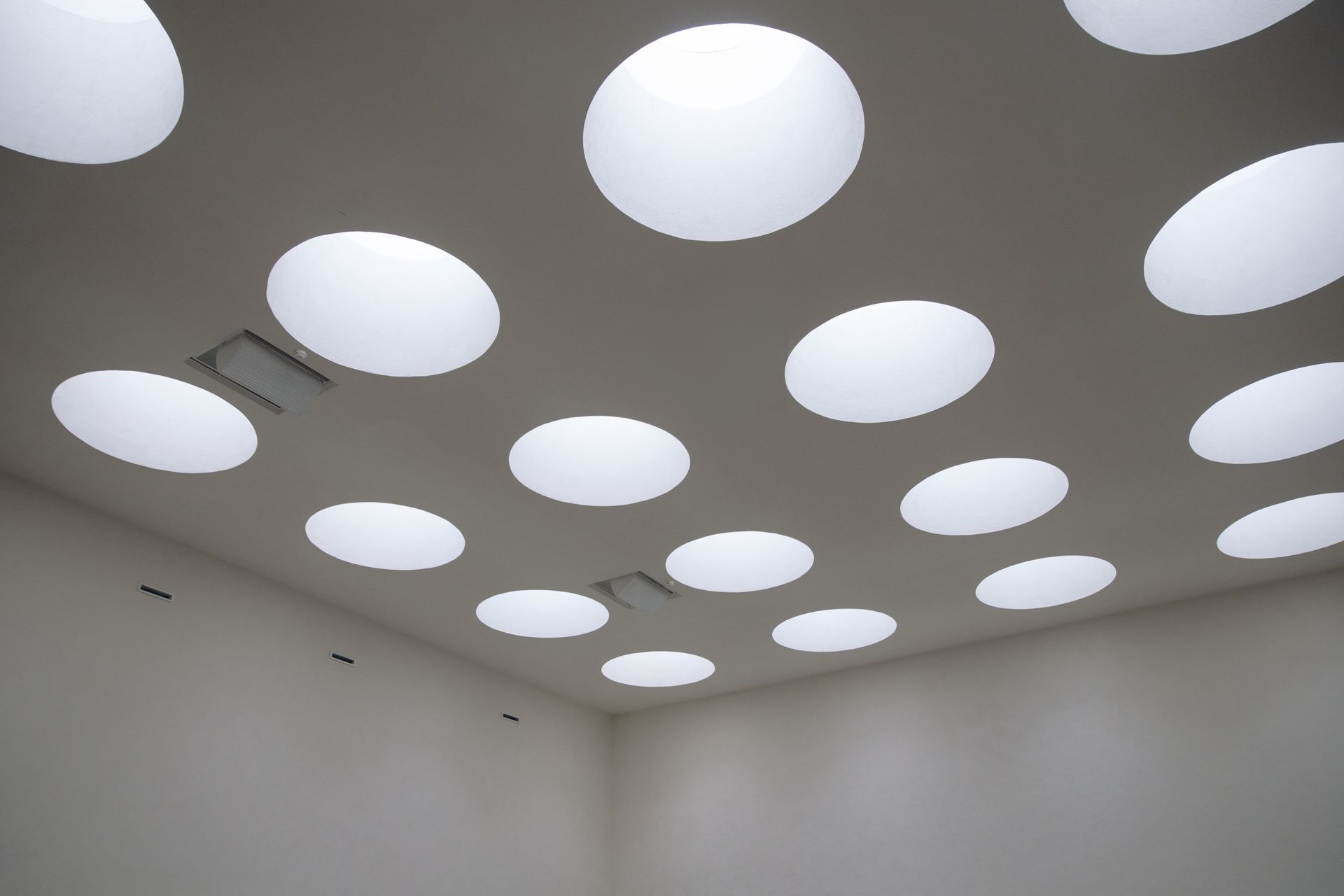 A modern room featuring circular ceiling lights creating a unique geometric pattern.