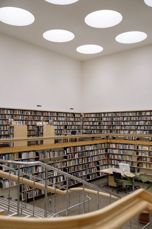 Free A spacious modern library with high bookshelves, skylights, and open reading areas. Stock Photo