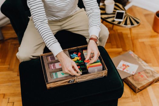 Adult male enjoying a board game in a cozy indoor setting, focused on organizing game pieces.