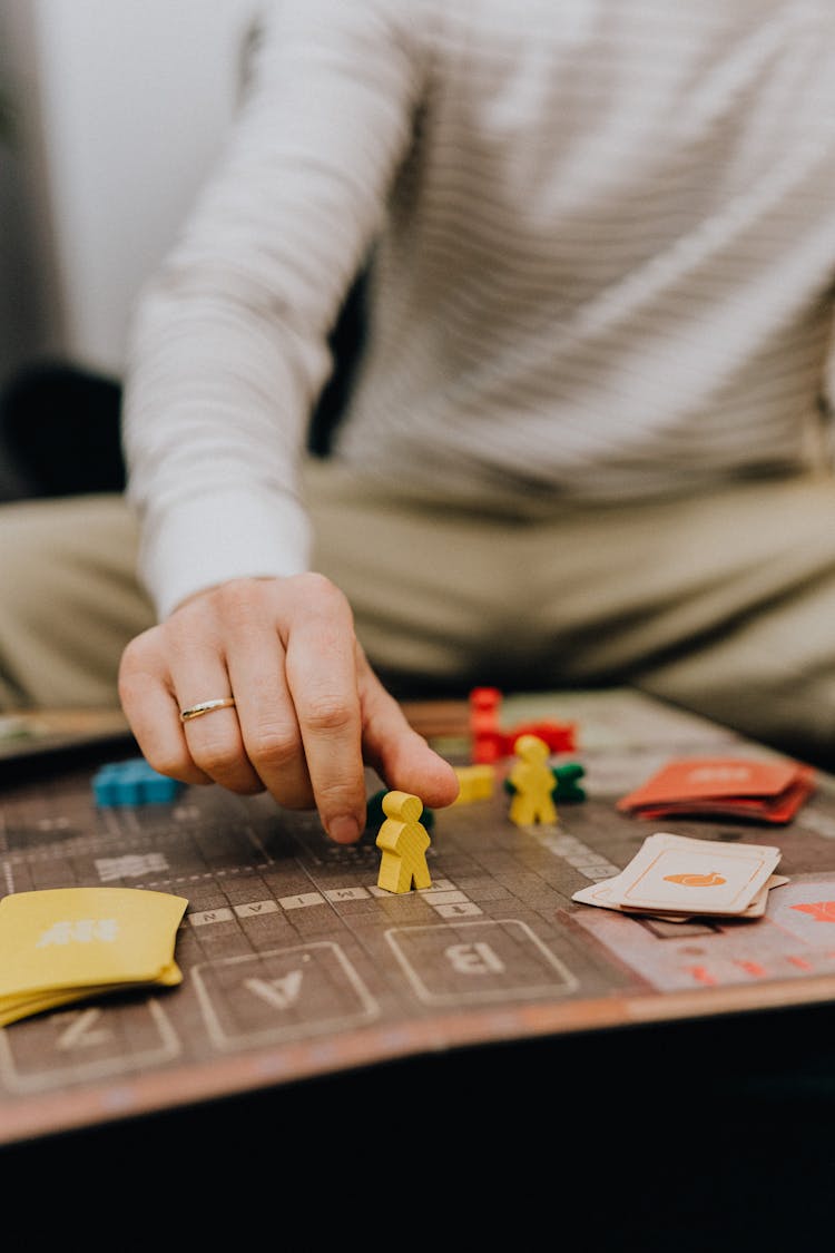 Close Up Of A Man Taking A Counter On A Game Board