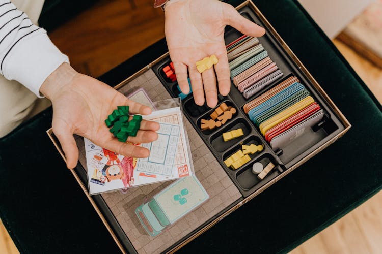 Top View Of Man Holding Counters From A Vintage Board Game 