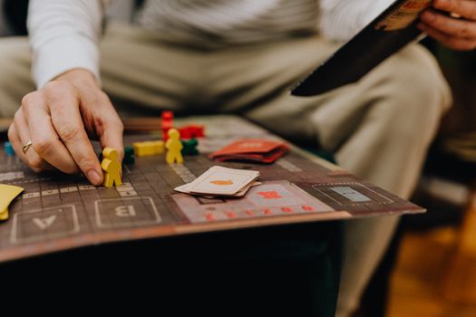 A person is engaged in a board game, focusing on strategic moves with colorful pieces.