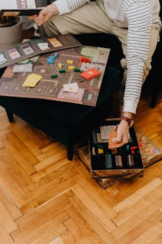 Person enjoying a board game on a wooden floor in a cozy room, depicting leisure time.