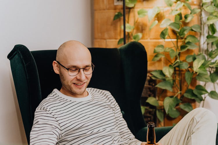 Happy Man Relaxing In Chair With Beer