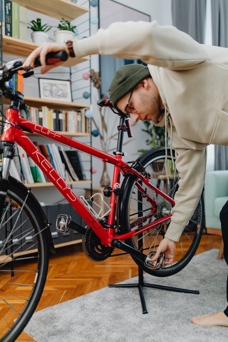 A Man With Green Knit Cap Holding The Bike's Pedal