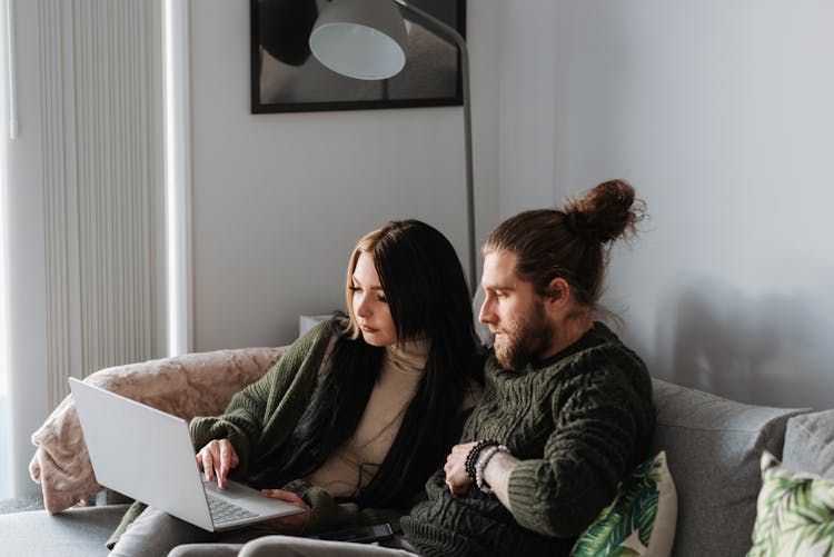 Couple Surfing Internet On Laptop In Living Room