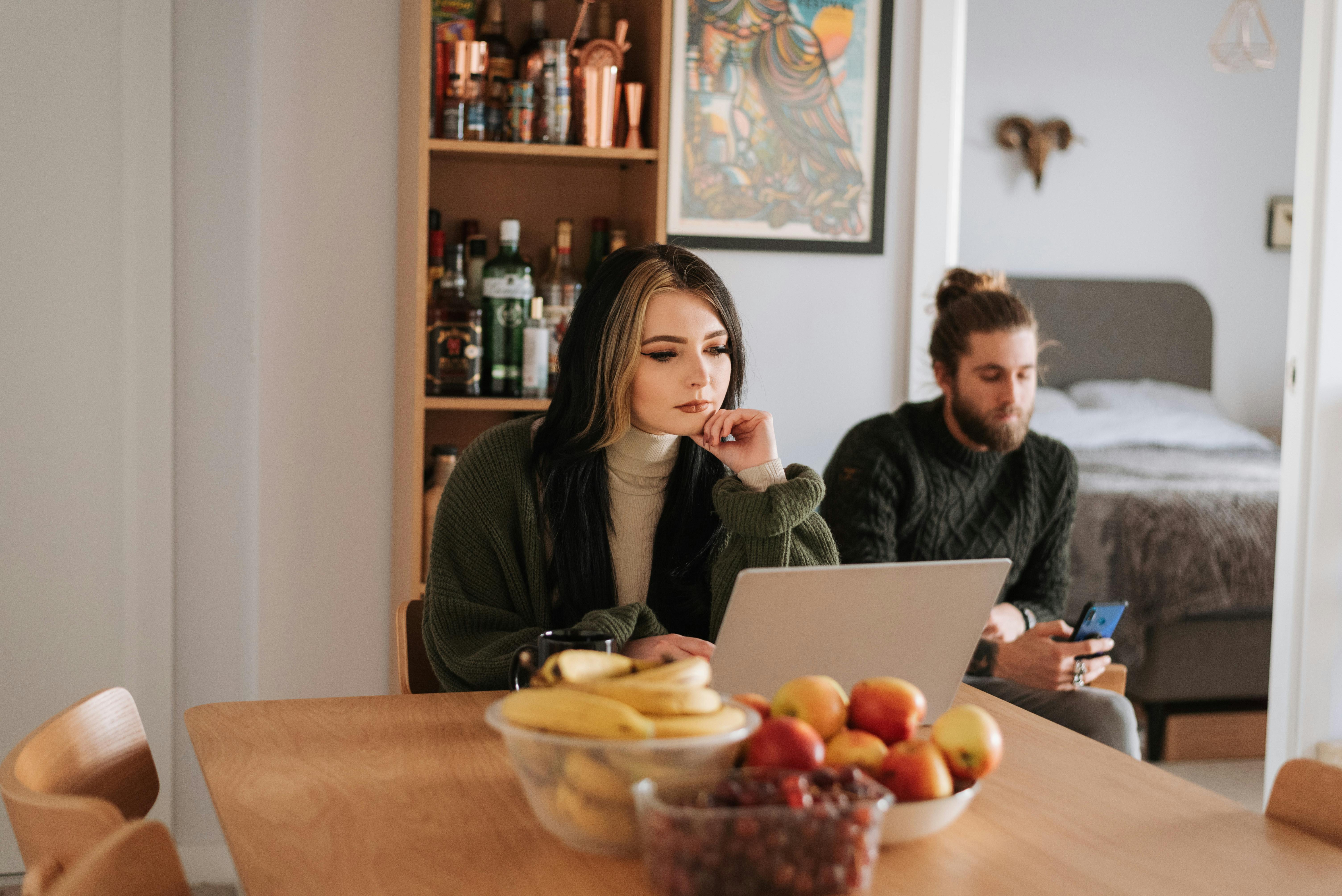 couple with laptop and smartphone in house room