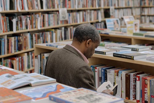 A Man Reading a Book on the Library