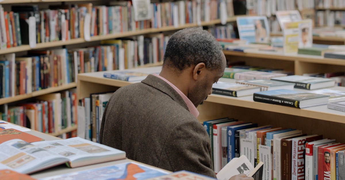 A Man Reading a Book on the Library · Free Stock Photo