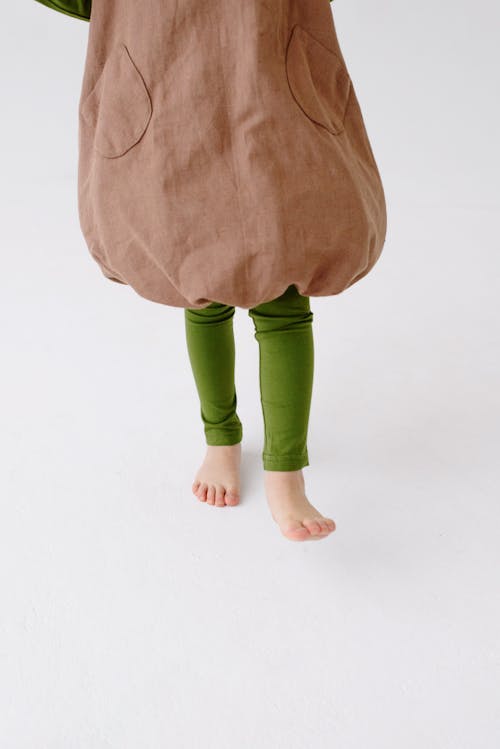 Barefooted Person in Green Leggings and Brown Loose Top