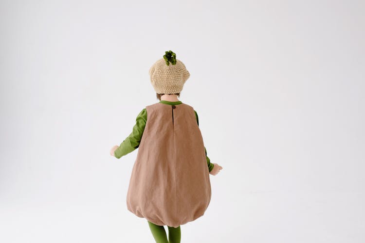 Girl In Brown Loose Romper With Green Leggings And Knit Hat Costume