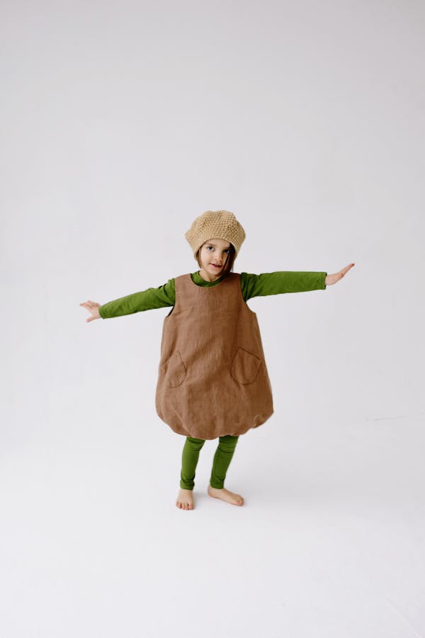 A Girl in Acorn Costume Posing with Arms Raised on Both Sides