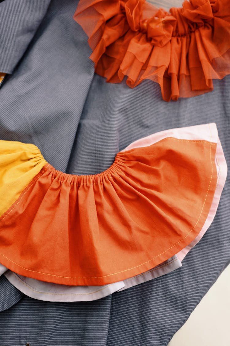 Orange And White Ruffled Skirt On Gray Textile