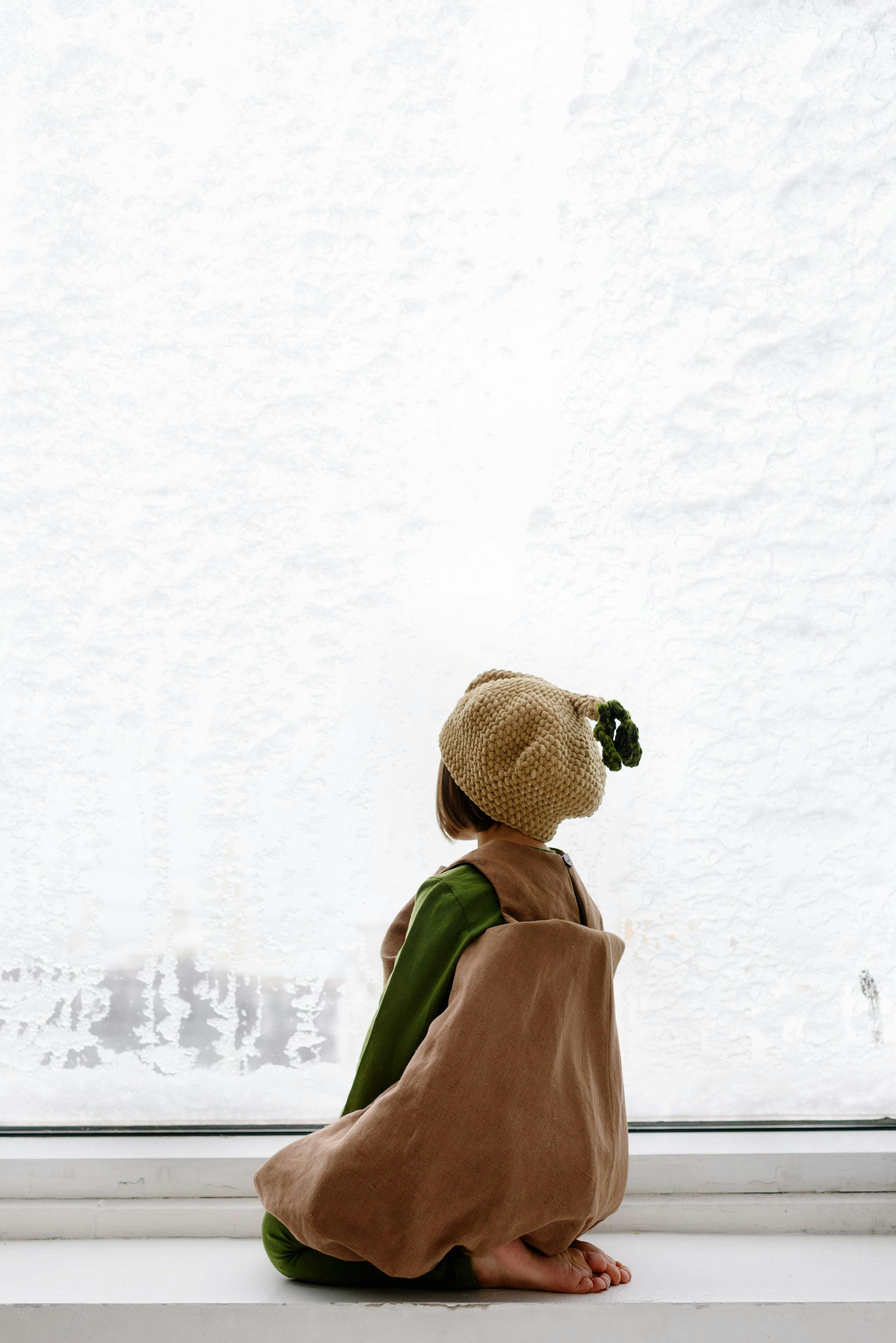 little girl sitting on the window sill