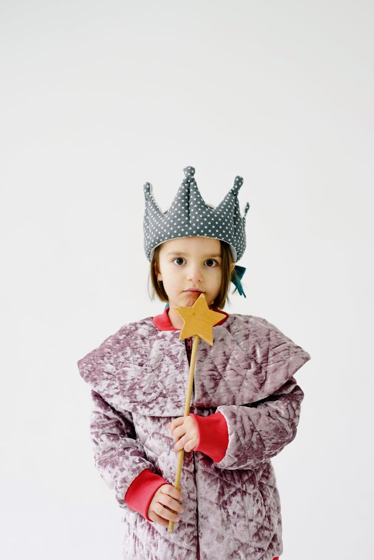 A Cute Girl In A Queen Costume Holding A Star Wand