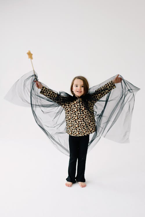 A Young Girl in Black Pants Holding a Wand