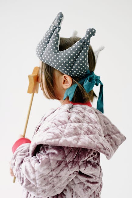 A child dressed in a starry crown and holding a wand, wearing a cozy quilted coat.
