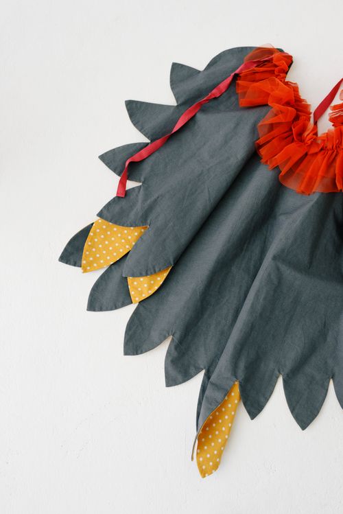 Free Vibrant hand-sewn costume cloak with orange and yellow accents displayed against a clean white backdrop. Stock Photo