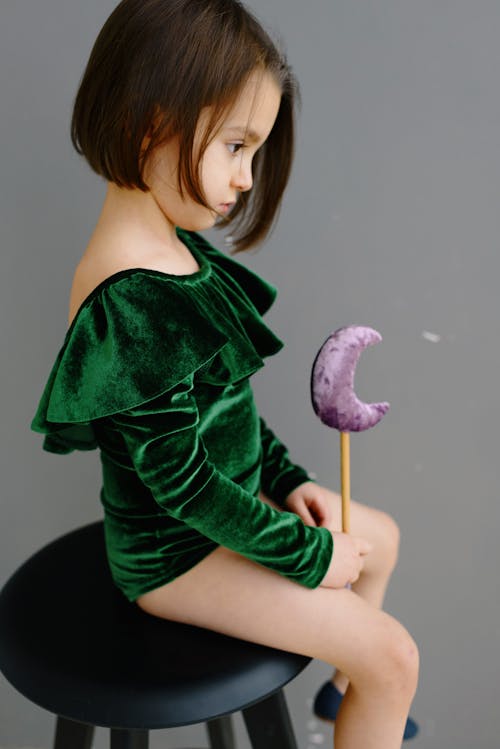 A Girl in Green Ruffled Leotards Holding a Crescent Moon Wand