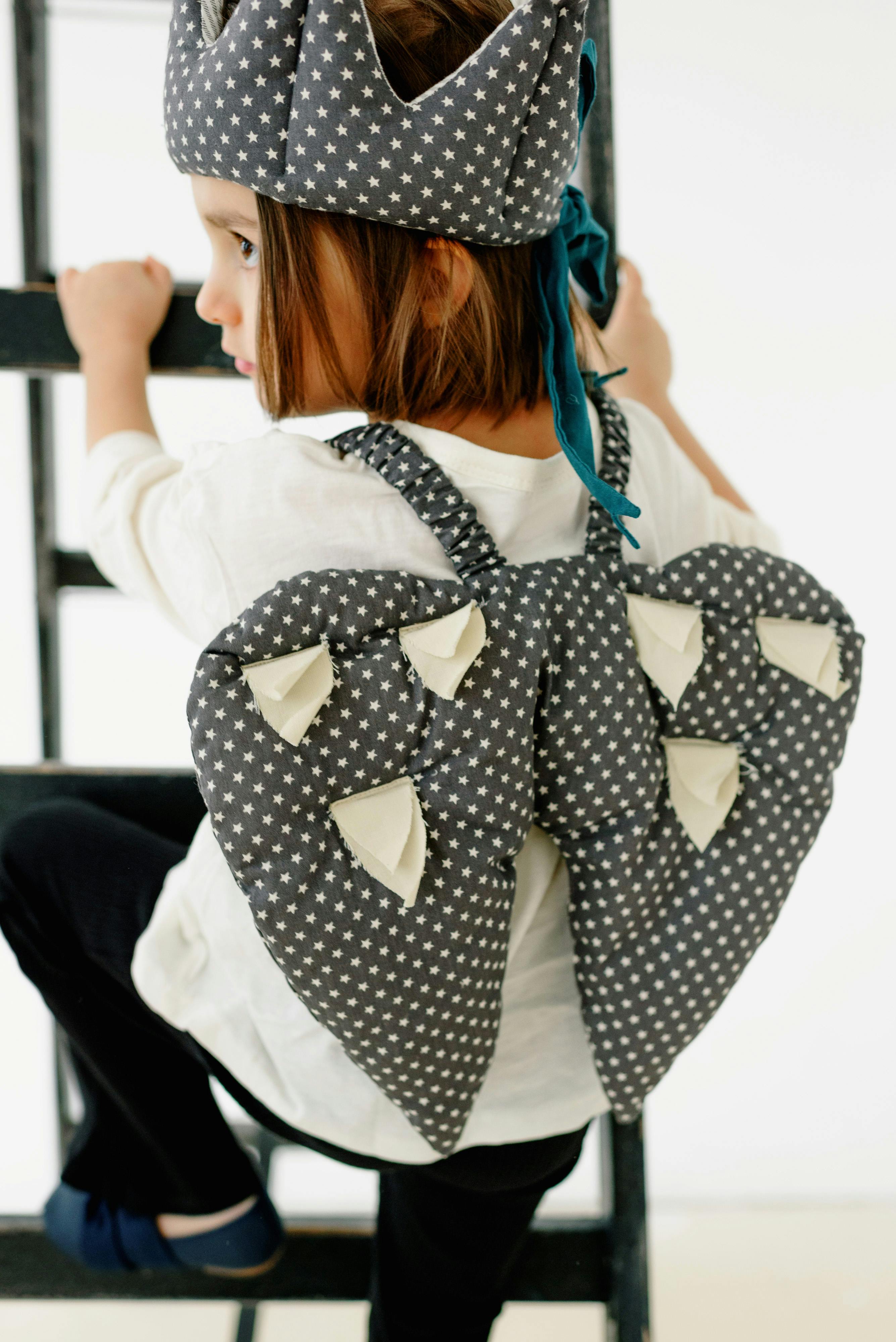 child in costume on ladder