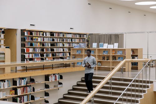 A Man Walking Down the Stairs with a Book