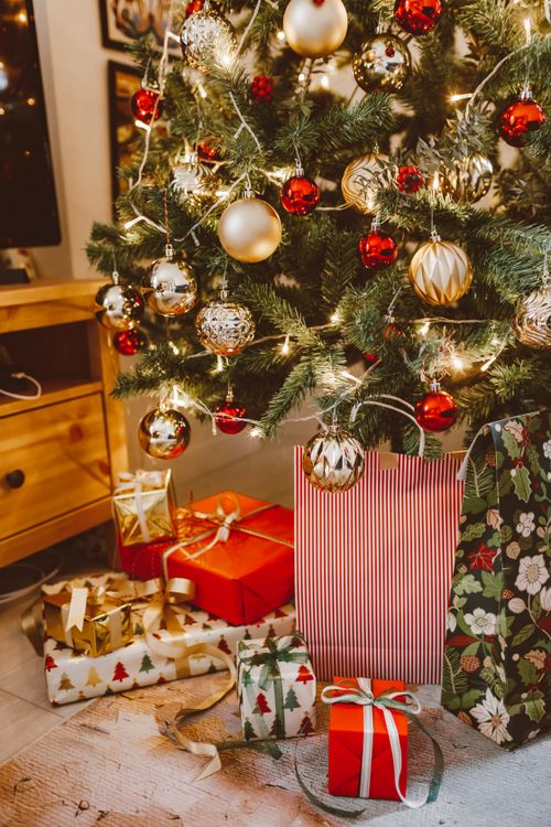 Free Warm holiday scene with a decorated Christmas tree and presents underneath. Stock Photo